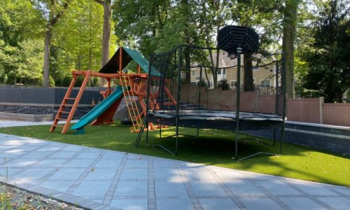 a swingset and trampoline next to each other in the backyard grass