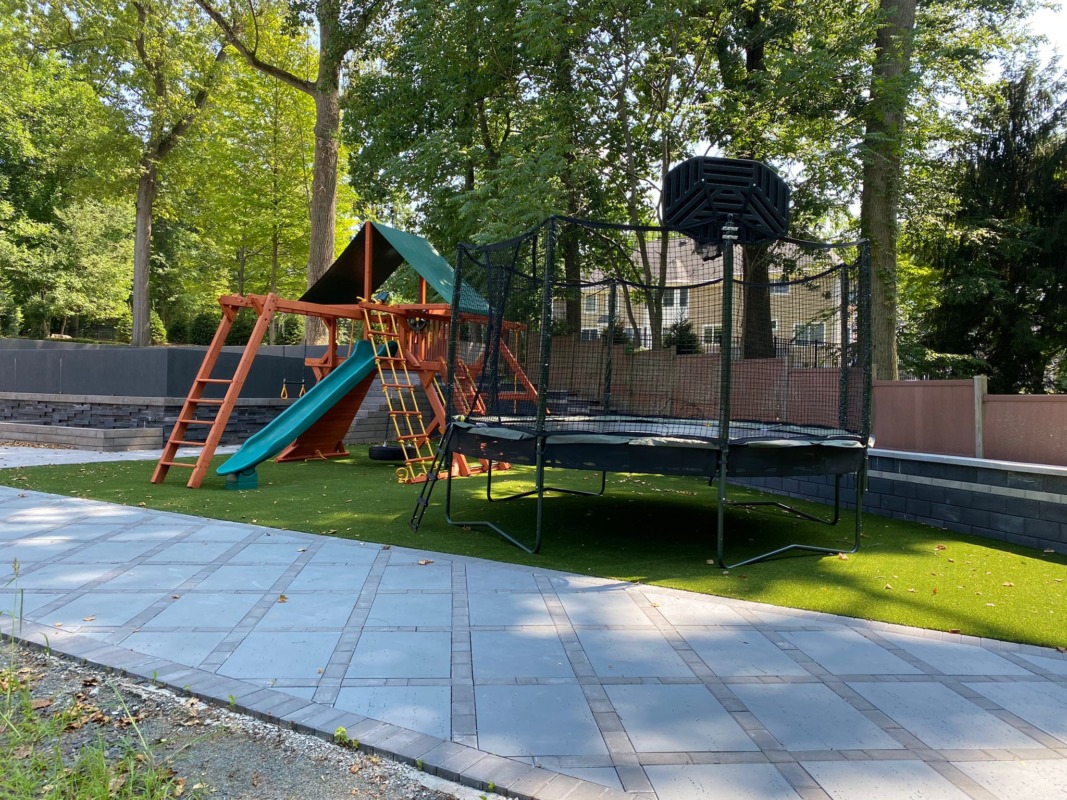 a swingset and trampoline next to each other in the backyard grass